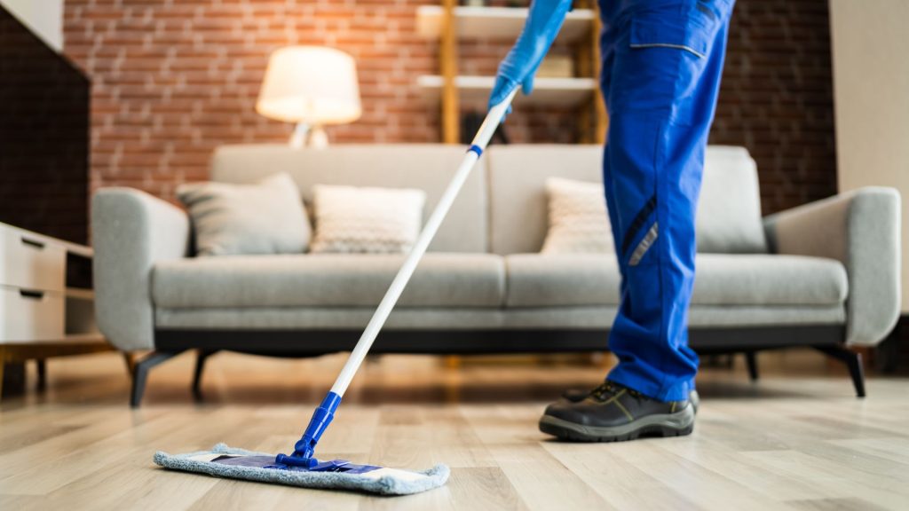 professional in blue pants using equipment to clean hard surface floor